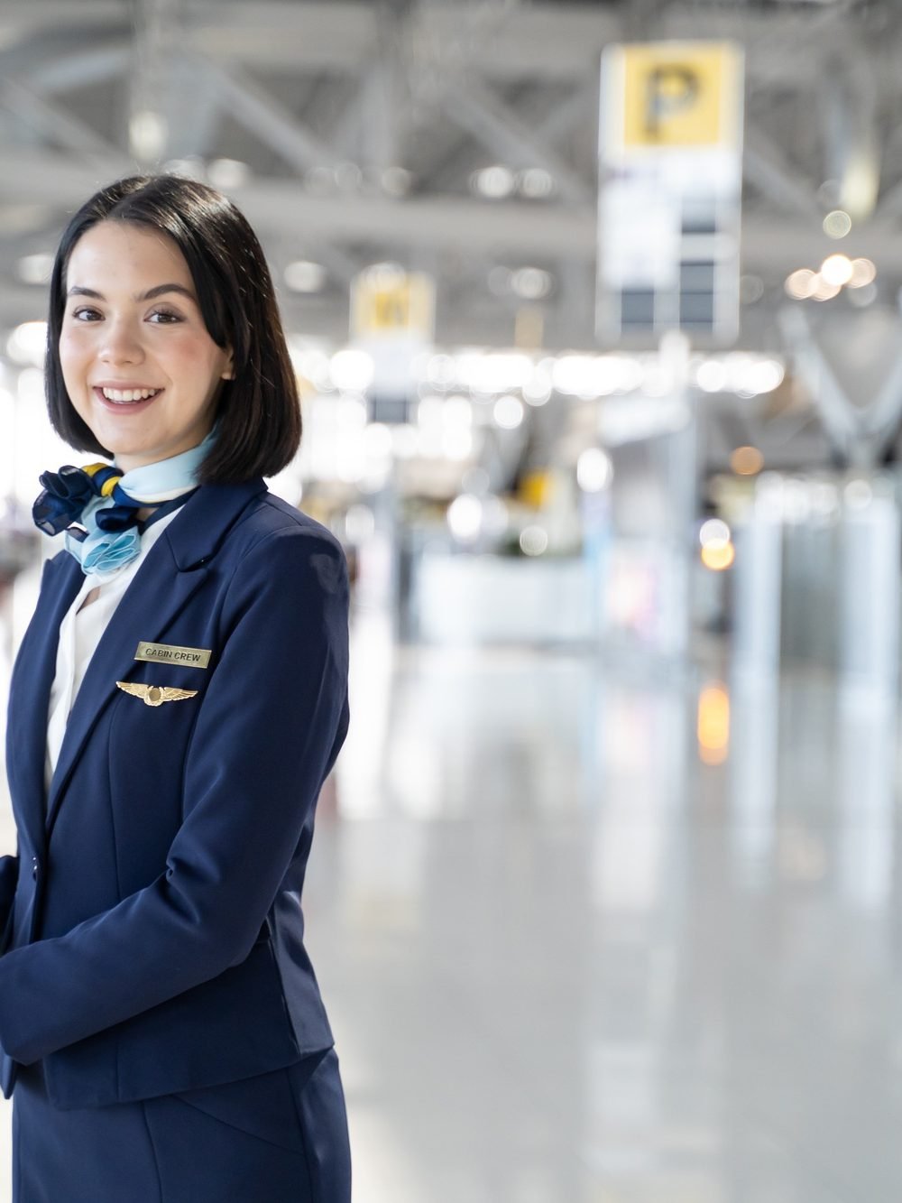 Portrait of Caucasian flight attendant standing in airport terminal.